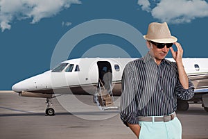 Handsome man standing outside a private jet