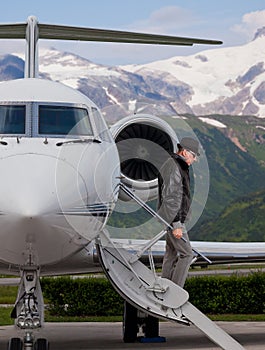 Handsome man on the steps of a private jet