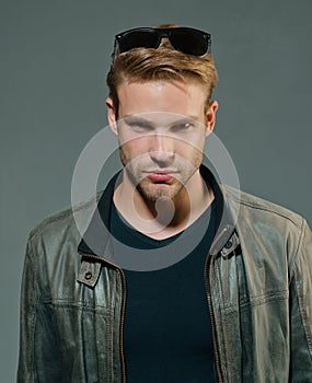 Handsome man - studio portrait. Close-up portrait of cheerful young man on gray background with copy space.