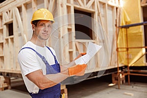 Handsome man studying architectural plan at construction site