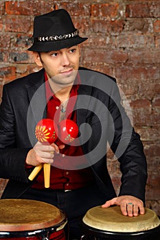 Handsome man in suit and hat poses with maracas photo