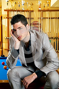 Handsome man with suit sitting in billiard pool