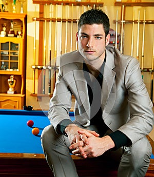 Handsome man with suit sitting in billiard pool