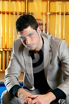 Handsome man with suit sitting in billiard pool