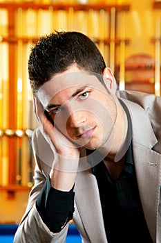 Handsome man with suit sitting in billiard pool