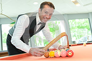 Handsome man with suit sitting in billiard pool in club