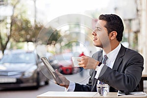 Handsome man with suit is using laptop in cafe