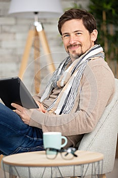 handsome man surfing on tablet on couch