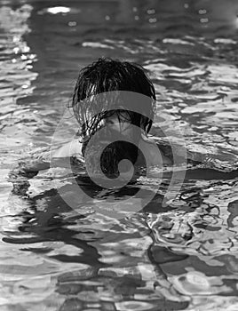 Handsome man swims in pool