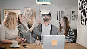 Handsome man takes off glasses virtual reality after using new app share experiences with team in the startup office.