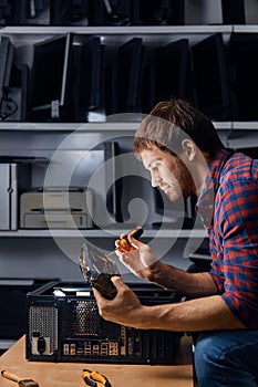 Handsome man taking the old computer equipmnet apart