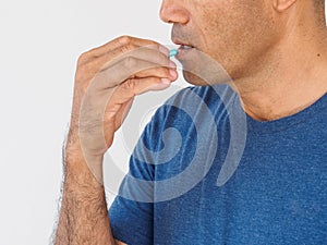 Handsome man taking pill on white background. Healthcare and med