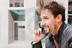 Handsome man telephoning on the street of his city. smartphone and lifestyle concept