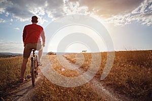 Handsome man traveling with bicycle in sunset, healthy active lifestyle traveler