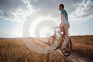 Handsome man traveling with bicycle in sunset, healthy active lifestyle traveler