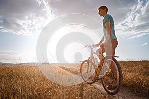 Handsome man traveling with bicycle in sunset, healthy active lifestyle traveler