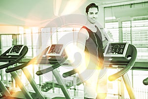 Handsome man on treadmill drinking water