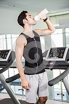 handsome man on treadmill drinking water