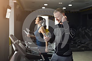 Handsome man on treadmill in fitness club