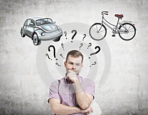 A handsome man is trying to chose the most suitable way for travelling or commuting. Two sketches of a car and a bicycle are drawn