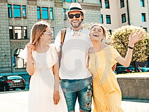 Handsome man and two beautiful women posing outdoors