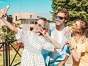 Handsome man and two beautiful women posing outdoors