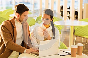 Handsome man typing on laptop keyboard and worried girl looking at screen