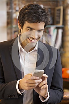Handsome man using a cell phone in coffee bar