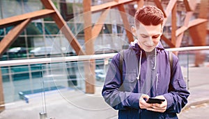 Handsome man using cell phone outdoor city street, Young attractive student casual blue shirt talking