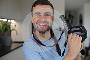 Handsome man using a retro video camera