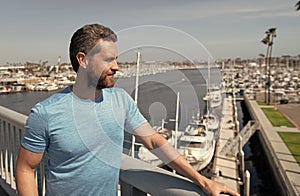 Handsome man vacationer stand at bridge railing over river summer outdoors, vacation