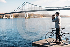 handsome man with vintage film camera and bike standing