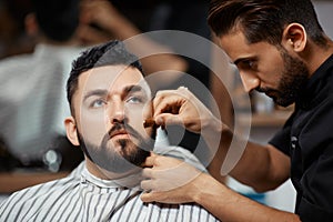 Handsome man visiting barbershop for corection bread.