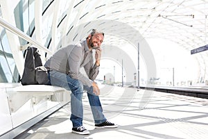 Handsome man waiting at train platform with phone