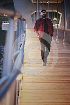 Handsome man walking on a bridge