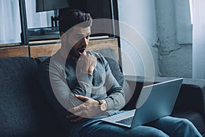 Handsome man watching pornography while sitting