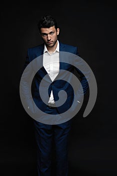 Handsome man wear blue suit isolated on black background.