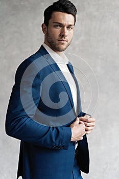 Handsome man wear blue suit isolated on grey background.