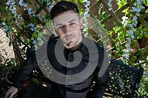 Handsome man wearing black shirt with blue eyes and beard looks into camera