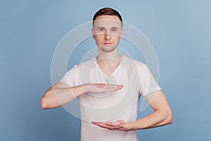 Handsome man wearing casual clothes gesturing with hands showing big and large size sign measure symbol isolated over