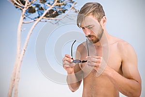 Composite image of handsome man wearing hat sunglasses