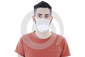 Handsome man wearing medical face mask because of air. Man social distancing from corona virus covid-19. Looking at camera