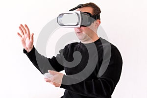 Handsome man wearing and playing virtual reality on isolated white background. Boy action in virtual reality helmet. VR glasses.