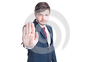 Handsome man wearing suit making stop gesture