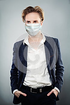 Handsome man wearing suit and surgical face mask, Covid-19 coronavirus concept