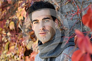 Handsome man wearing winter clothes in autumn leaves background