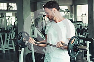 Handsome Man is Weight Exercising With Bodybuilder Equipment in Fitness Club. Portrait of Strong Man Doing Working Out Body