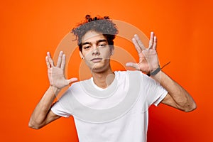 handsome man white t-shirt hand gestures emotions orange background