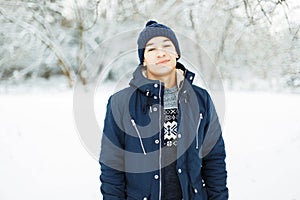 Handsome man in a winter jacket and a sweater walks.