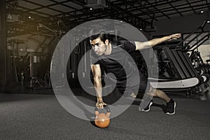 Handsome man working out  push-up strength with Kettlebell  at gym